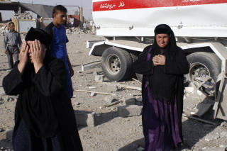 DRAP UTEN ANSIKT: To anonyme lastebiler ble brukt som gjemmested for de to bombene som tok 23 liv ved Khaznah i dag. AFP PHOTO/MUJAHED MOHAMMED/Scanpix