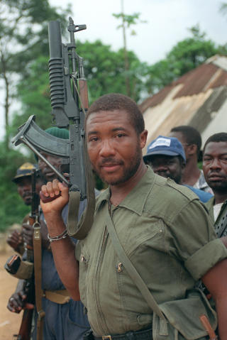 P� KRIGSSTIEN: Dette bildet fra mai 1990 viser Charles Taylor med en AK-47 rifle p� vei mot hovedstaden Monrovia for � kaste president Samuel Doe. Foto: AFP PHOTO/FILES/PASCAL GUYOT/SCANPIX