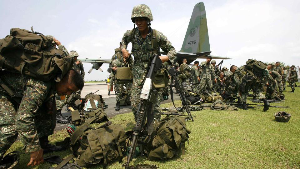 RYKKER INN: Filippinske regjeringssoldater gj�re seg klare til � kjempe mot ekstremistgrupper p� �ya Basilan. Minst 43 personer ble drept i kraftige sammenst�t i g�r. Foto: REUTERS/SCANPIX