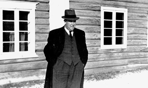 Krigen i Norge etter tyskernes overfall 9. april 1940. Konge og Regjering flykter nordover. Her står statsråd Trygve Lie utenfor et hus i Nordland under flukten. Den mektige ministeren forsøkte å tilsløre det som virkelig skjedde 15. april, da regjeringen havnet noen hundre meter unna kampene mellom Eiliv Austlids kompani og tyske fallskjermjegere. Foto: SCANPIX Krigen i Norge etter tyskernes overfall 9. april 1940. Konge og Regjering flykter nordover. Her står statsråd Trygve Lie utenfor et hus i Nordland under flukten. Den mektige ministeren forsøkte å tilsløre det som virkelig skjedde 15. april, da regjeringen havnet noen hundre meter unna kampene mellom Eiliv Austlids kompani og tyske fallskjermjegere. Foto: SCANPIX