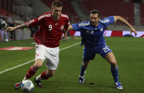 SJOKKOVERGANG: Sotiris Kyrgiakos (t.h.), som er best kjent i Norge for � drept det norske EM-h�pet med to scoringer p� Ullevaal i 2007. N� skal grekeren etter sigende v�re klar for Liverpool.  Her er han i duell med danske Nicklas Bendtner. Foto: SCANPIX/AP Photo/Thanassis Stavrakis