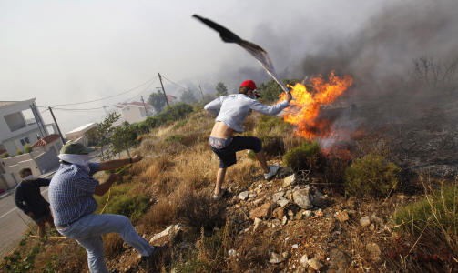 HAGESLANGE OG FLAGG:  Innbyggere �st for Aten i nyttel�s kamp mot flammene p� knuskt�rr grunn. Foto: AFP/SCANPIX.