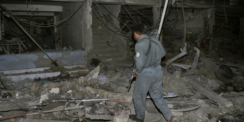 STORE SKADER: En afghansk politimann unders�ker ruinene til et av bygningene som ble rammet av en stor eksplosjon i Kandahar i Afghanistan.  Foto: AP Photo/Allauddin Khilji/Scanpix