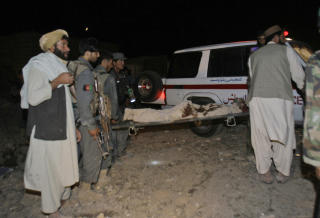 DREPT: Her blir en person f�rt bort etter at en bombe drepte minst 35 mennesker i Afghanistan. Foto: AP Photo/Allauddin Khilji/Scanpix