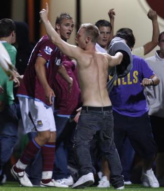 STORMET BANEN: Supportere stormet banen tre ganger i g�r kveld. Her fors�ker Jack Collison � overtale dem til � g� opp p� tribunen igjen. Foto: REUTERS