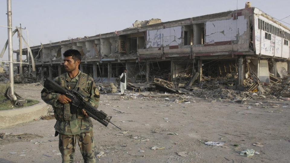 MINST 43 DREPT: En afghansk soldat st�r utenfor �stedet for bombeangrepet i Kandahar i S�r-Afghanistan tirsdag. Taliban nekter for � st� bak angrepet. Foto: AP/SCANPIX