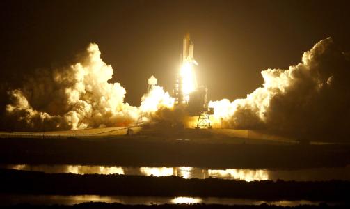 SPEKTAKUL�RT SYN: Kennedy Space Center badet i et oransje lys da rakettene p� sidene av Discoverys drivstofftank ble antent. Foto: SCANPIX/EPA/Justin Dernier