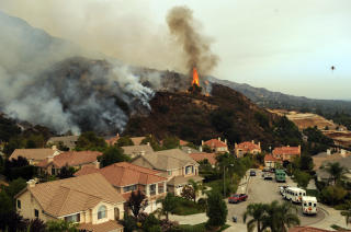 TRUER: Flammene n�rmer seg hus i Glendale i Los Angeles. Myndighetene mener de er menneskeskapte, og fors�ker n� � finne ut om brannene er p�satt med overlegg eller ikke. Foto: Scanpix/AFP PHOTO / GABRIEL BOUYS