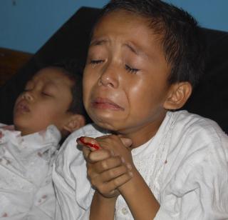 GR�TER: En skadd gutt fra Tasikmalaya, Vest-Java, gr�ter mens han venter p� hjelp p� et sykehus. Foto: REUTERS/Stringer