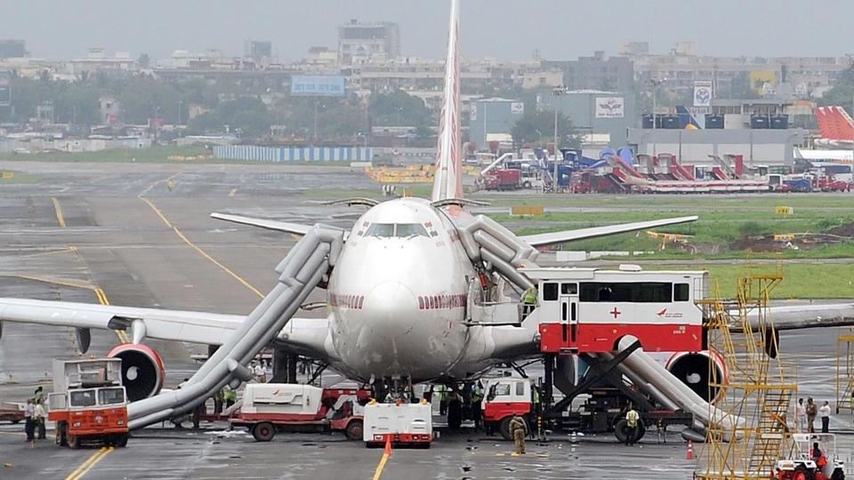 EVAKUERT: Dette flyet tok fyr da det var p� vei mot rullebanen for avgang. Foto: Indranil Mukherjee/AFP/Scanpix