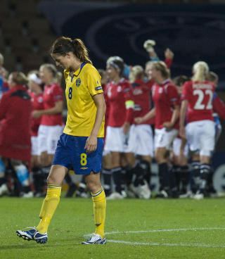 SVENSK SKUFFELSE: Lotta Schelin g�r duknakket over banen mens de norske jentene feirer i bakgrunnen.Foto: Jonas Ekstr�mer, Scanpix