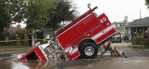 REDDET:  Brannbilen ble senere dratt opp av gj�rma med kran. Foto: Scanpix/AP Photo/Nick Ut