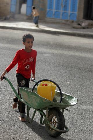 P� VEI ETTER VANN: En liten gutt med trilleb�r i Sanaa i slutten av august. Krigen har n� vart en m�ned og titusener er p� flukt. Foto: REUTERS/Khaled Abdullah