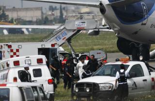 - P� OPPDRAG FRA GUD: Her blir Jose Mar Flores Pereira f�rt av flyet. Foto: SCANPIX/AP Photo/Marco Ugarte
