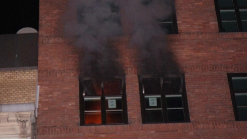 R�YK OG FLAMMER: Brannen er i femte etasje. R�ykdykkere er n� inne i kontorlokalene. Foto: ROGERIO SNARLI