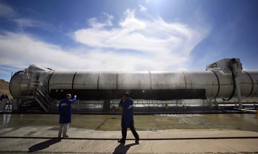 RYKENDE: Ingeni�rer fra Alliant Techsystems, som leverer det f�rste trinnet p� Ares I, inspiserer raketten etter endt testfyring. Foto: Scanpix/AP Photo/Colin Braley