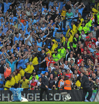 PROVOSERTE: Emmanuel Adebayor feiret sin 3-1-scoring foran bortefansen. Det satte sinnene i kok. Foto: Andrew Yates / AFP.