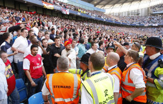 VAKT SKADET: En gjenstand kastet inn p� banen av Arsenal-supporterene traff en vakt som ble sendt p� sykehus. Foto: AP/Jon Super