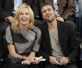 KJENDISJUBEL: Skuespiller Charlize Theron og kj�resten Stuart Townsend var blant tilskuerne da Federer fikk fulltreff. Foto: Kathy Willens, AP/Scanpix
