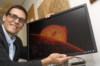 FORN�YD:  Den sveitsiske astronomen Didier Queloz poserer med en illustrasjon av Corot-7b, som han bidro til � avdekke. Foto: EPA/SALVATORE DI NOLFI