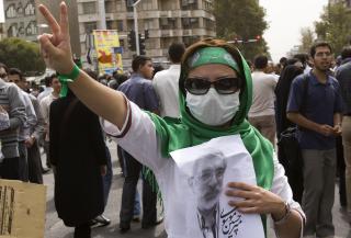 REFORMVENNLIGE: En tilhenger av Iran opposisjonleder Mir Hossein Mousavi holder en plakat med bilde av den tapende presidentkandidaten under freddagens demonstrasjon i Teheran. Foto: REUTERS/SCANPIX
 REUTERS/Caren Firouz