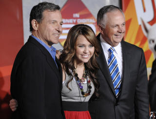 MAKTKAMP: Cook m�tte trolig g� etter en langvarig feide med Robert Iger (til venstre). Her poserer de begge med Miley Cirus. FOTO: SCANPIX/AP