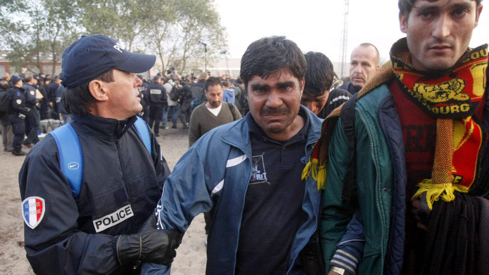 STORMET LEIREN: Fransk politi satte i morges i gang arbeidet med � fjerne hundrevis av flyktninger fra en provisorisk leir i Calais, Nord-Frankrike. Rundt et dusin kj�ret�y med oppr�rspoliti inntok leiren.Foto SCANPIX/AP/Michel Spingler