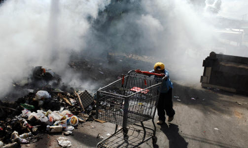 VOLDELIG: En liten gutt triller p� en butikktralle i Honduras' hovedstad Tegucigalpa en dag etter store sammenst�t mellom Zelaya-sympatis�rer og politi. Foto: AP Photo/Scanpix