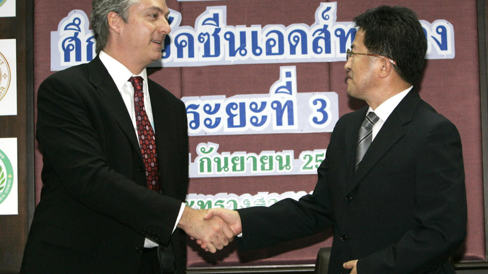 FORN�YDE: Den amerikanske ambassad�ren i Thailand, Eric John, gratulerer Thailands helseminister Witthaya Kaewparrdai etter pressekonferansen der resultatene av vaksinestudien ble presentert. Foto:AP/SCANPIX