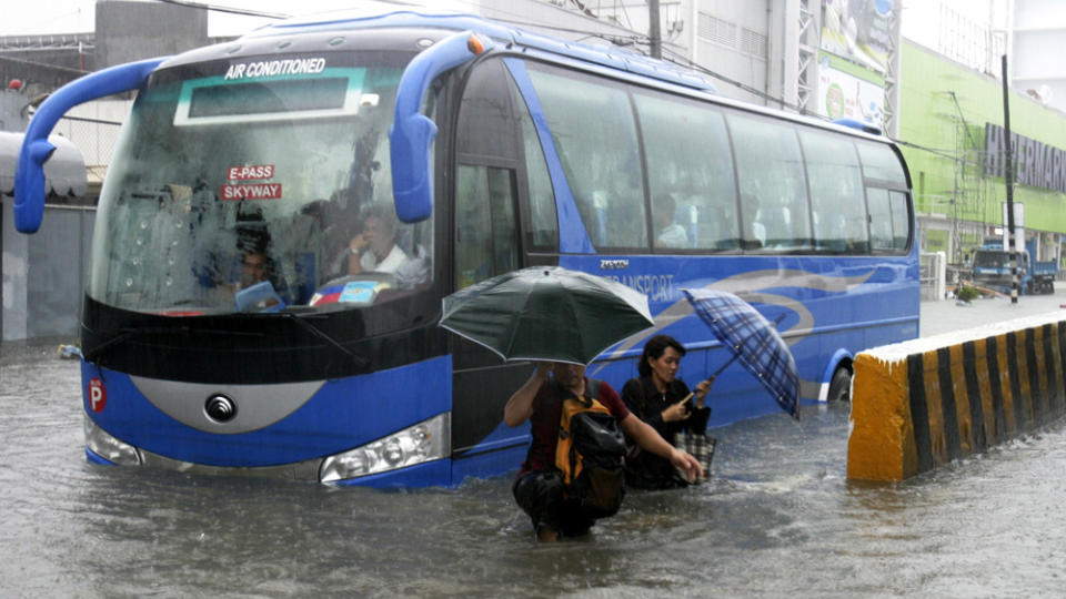 NATURKATASTROFE: Befolkningen i Manila pr�ver � la livet g� sin vante gang p� tross av at de m� vasse gjennom gater oversv�mmet av en meter vann. Foto: BULLIT MARQUEZ/AP/SCANPIX