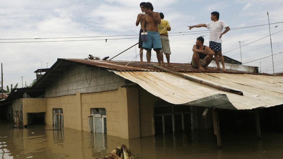 P� TAKET: Flomrammede s�ker tilflukt p� takene i Binan Laguna, s�r for hovedstaden Manila. Minst 240 personer er bekreftet d�de etter flommen p� Filippinene, og d�dstallene er ventet � stige n�r redningsarbeidere tar seg inn i det hardest rammede omr�dene. Foto: REUTERS/Erik de Castro