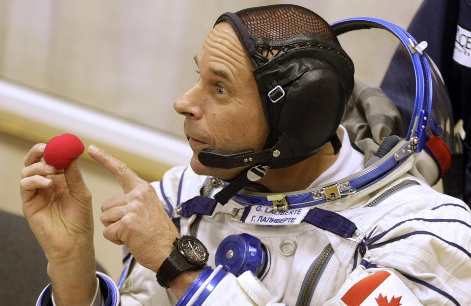 ASTROKLOVN: Fransk-kanadiske Guy Laliberte  viser frem favorittnesen f�r han i dag ble f�rste klovn i verdensrommet - p� vei til den internasjonale romstasjonen i Soyuz-FG raketten skutt opp fra Baikonur Cosmodrome i Kazakhstan. Romklovnen er ventet � v�re fremme ved stasjonen fredag, og varsler flere ableg�yer der. Foto: AP Photo/Mikhail Metzel/SCANPIX