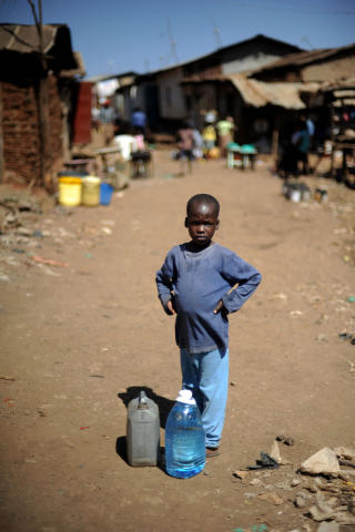 HENTER VANN: Unge fattige i Afrika s�r for Sahara rammes aller hardest av klimakrisa. Her henter en ung gutt i Kibera-slummen i Nairobi vann. Foto: AFP PHOTO / Roberto SCHMIDT / Scanpix