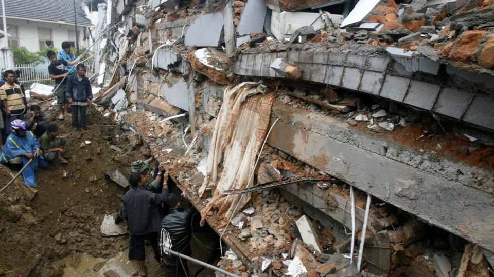 LETER ETTER SAVNEDE: En soldat og en frivillig pr�ver � lete etter savnede i en kollapset bygning i Padang.  Foto: REUTERS/Crack Palinggi/Scanpix