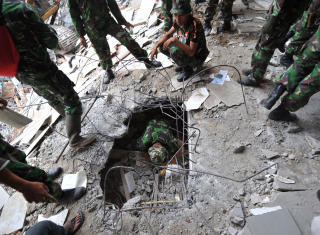 KNUST: Indonesiske soldater graver i ruinene p� desperat leting etter overlevende. Myndighetene frykter at flere tusen mennesker har mistet livet. Foto: Reuters