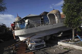 HUS RASTE OPP� BIL: Denne mannen klatrer ned fra et �delagt hus i byen Padang i Indonesia. Foto: AP/Kevin Frayer