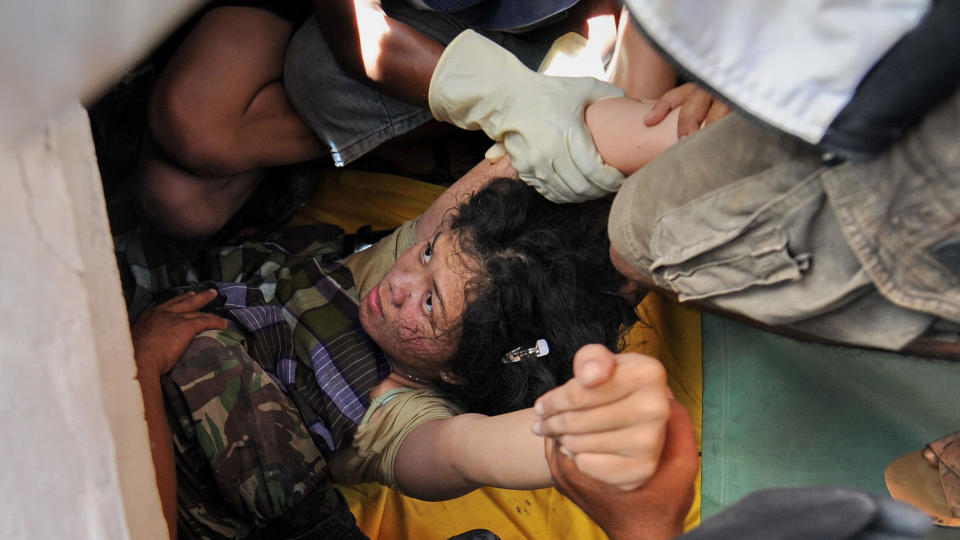 REDDET: En kvinne blir reddet ut fra en ruinene i Padang i Indonesia. Foto: AFP PHOTO/Scanpix