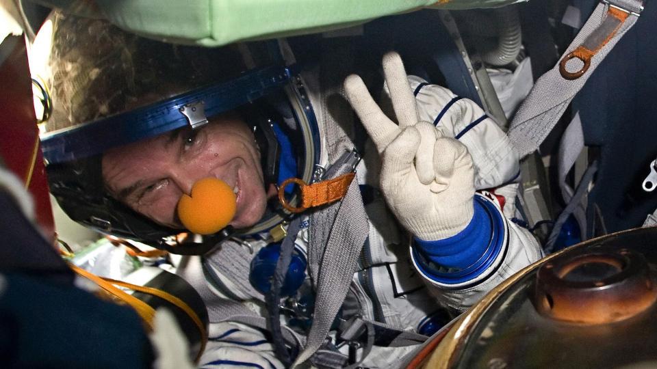 KLOVNET I BANE: Romturist, sirkusgrunnlegger og klovn Guy Laliberte brukte r�d nese da han tr�dte ut av russernes Soyuz TMA-16-romfart�y i dag. Laliberte, som betalte 200 millioner for turen til ISS, fikk 10 dager i verdens rommet. Foto: AFP PHOTO/ POOL/ SERGEI REMEZOV/Scanpix