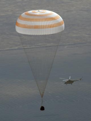 FALLSKJERM: Soyuz-kapselen seiler ned mot steppene i Kazahstan. Ombord satt kosmonaut Gennady Padalka, NASA-astronaut Michael Barratt og romturist Guy Laliberte Foto: AP Photo/Yuri Kochetkov/Scanpix