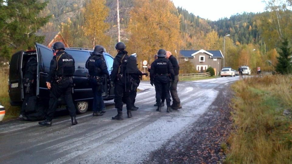 BEV�PNET POLITI UTENFOR HUSET: Det er i det gr� huset i bakgrunnen at en mann i 20-�rene har forskanset seg. Han har knivstukket sin tidligere samboer, men er n� i dialog med politiet. FOTO: MARTIN H�GENSEN