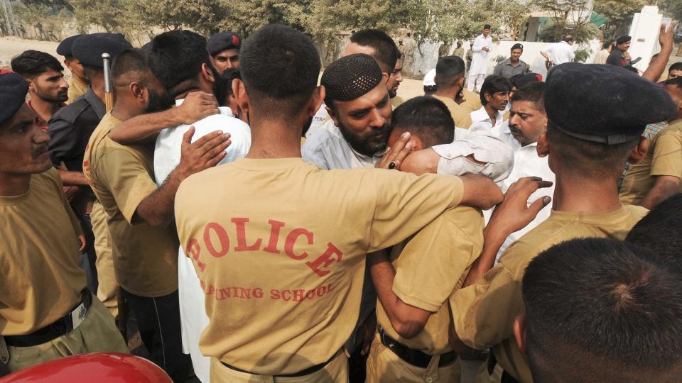 TR�STER HVERANDRE:  Medlemmer av den pakistanske h�ren tr�ster politi som kom seg ut av Manawan Police Acadamy i Lahore, Pakistan, etter at en bev�pnet gruppe angrep bygningene. Foto: EPA/Scanpix