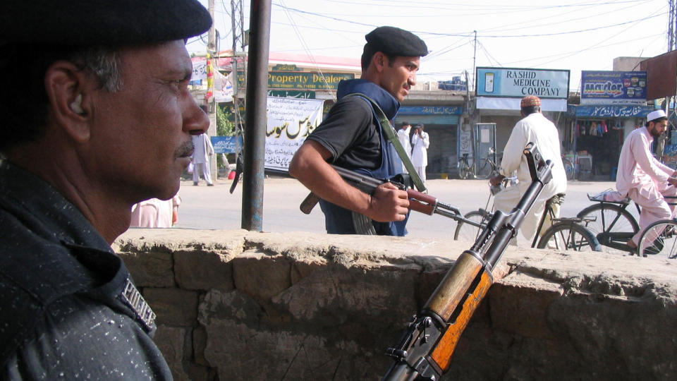 HOLDER VAKT: Pakistanske politimenn holder vakt ved en sikkerhetspost i Dera Ismail Kahn i Pakistan i dag. Rundt dem flykter sivile for � komme unna krigen. FOTO: AFP/ MOHAMMAD KASHIF