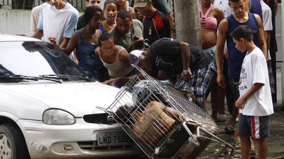 DREPT: Skuelystne str�mmet til da en mann ble funnet d�d i ei handlevogn i dag. Mannen skal ha blitt drept av en rivaliserende narkobande. Foto: REUTERS/Ricardo Moraes/Scanpix