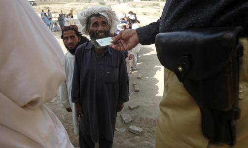 SJEKKPUNKT: En politimann sjekker indentitetskortet til en mann som flykter fra krigshandlingene i S�r-Waziristan. Foto: REUTERS/Faisal Mahmood