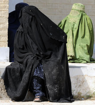 TVANGSINNF�RTE BURKA: I stammeomr�dene i Pakistan g�r kvinnene i burka og holdes innend�rs. Disse tre kvinnene er flyktninger fra S�r-Waziristan. Her venter de p� mat i landsbyen Paharpur. Foto: AFP/ AAMIR QURESHI