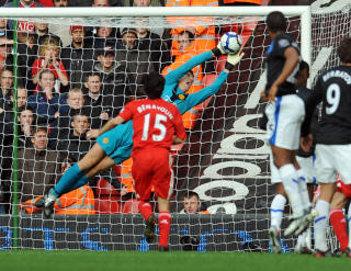 STOPPET AURELIO: Edwin van der Sar strekker seg mot krysset for � stoppe et Fabio Aurelio-frispark. Foto: AFP