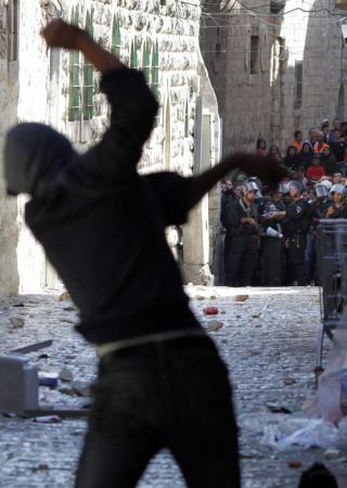 STEIN: En palestiner kaster stein mot oppr�rspoliti. En hel rekke demonstranter stengte seg inne i Al-Aqsa-moskeen f�r oppt�yene endte. EPA/NATI SHOHAT ISRAEL OUT