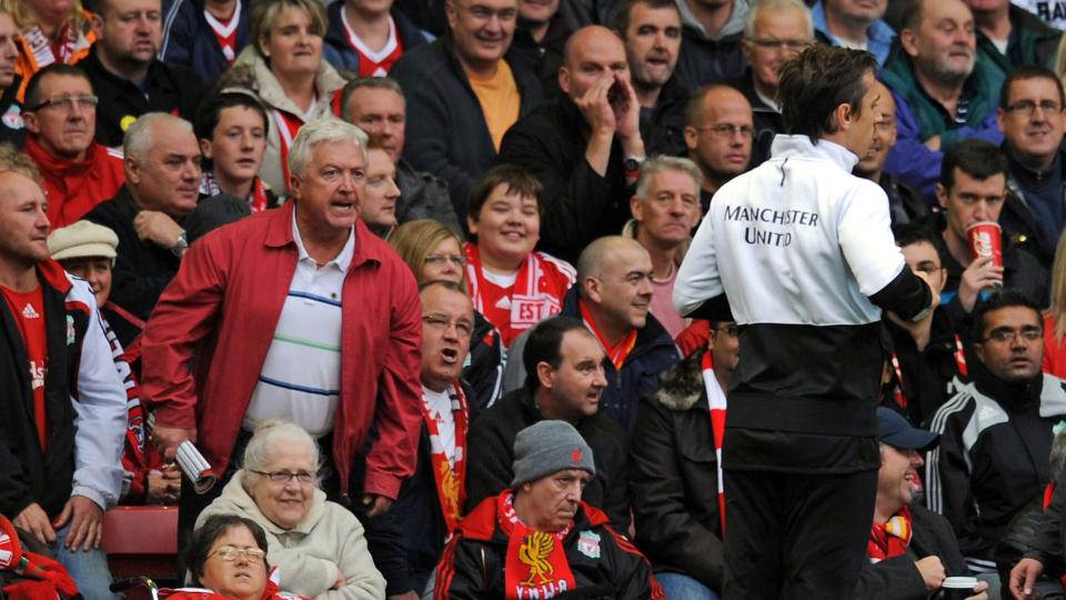 FIKK TYN: Det var neppe lykke�nskninger disse Liverpool-supporterne skrek ut i retning Gary Neville da United-kapteinen varmet opp langs sidelinja under g�rsdagens kamp p� Anfield. Senere skal United-kapteinen ha tatt til motm�le - og etter kampen havnet han i full krangel med en Liverpool-vakt som nektet ham � jogge ned der hjemmefansen sto. Foto: AFP PHOTO/PAUL ELLIS