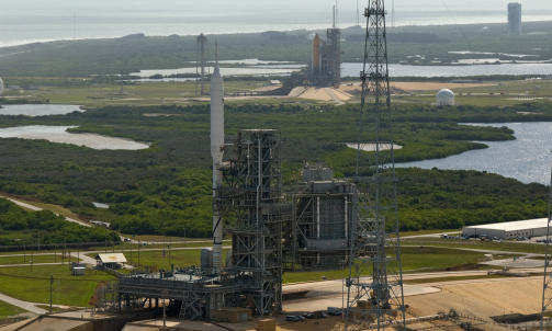 HISTORISK SYN... p&aring; Kennedy Space Center. I forgrunnen st&aring;r romfartens mulige framtid, Ares I-X, p&aring; plattform 39B, mens romferja Atlantis danner bakteppet. Dette er trolig f&oslash;rste og siste gang de to st&aring;r side om side. Sist et annet fart&oslash;y sto her var i 1975 - da en Saturn I-B. Foto: NASA