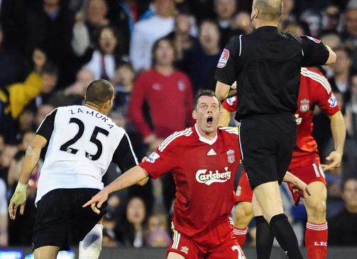 STORE �YNE: Dommer Lee Mason gikk ikke glipp av hva som skjedde, og viste Carragher direkte r�dt kort. Det hjelper ikke at Liverpool-kapteinen peker p� ballen og gj�r store �yne.Foto: Toby Melville, Reuters/Scanpix